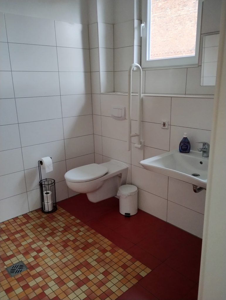 Modernes, barrierefreies Bad mit Dusche, WC und Waschbecken, vollständig gefliest