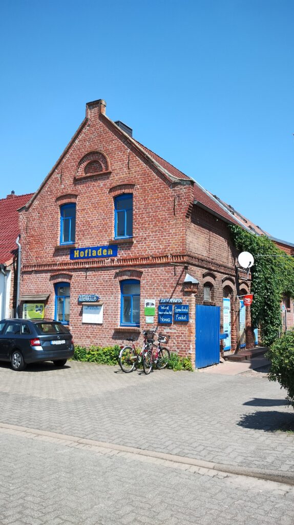 Front und Eingang eines Hofladens am Haupttor des Bauernhofs in einem Haus mit Klinkerfassade