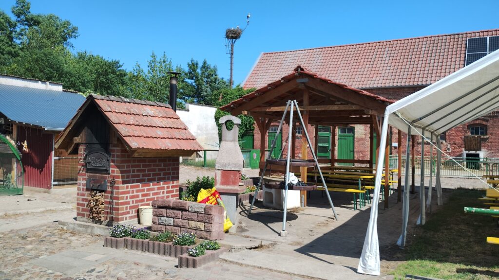Kachelofen und Grill auf dem Innenhof eines Bauernhofs mit Sitzmöglichkeiten und Pavillon zum Essen
