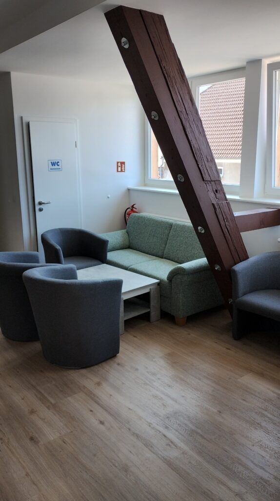 Clubraum mit Sesseln, einer Couch und Fernseher